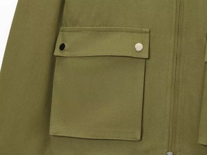 Detailed close-up of khaki canvas jacket featuring utility flap pocket and snap buttons