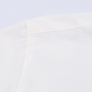 Detailed view of white poplin shirt shoulder with neat double-needle stitching quality