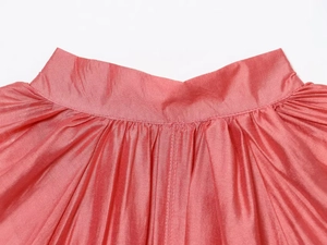 Macro shot of coral pink satin shirt with wide waistband and pleated lantern sleeve detail