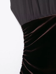 Detail of ruched burgundy velvet and black matte fabric patchwork on evening dress