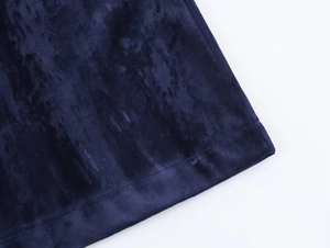 Close-up of premium dark blue velvet fabric showing fine texture and neat stitching