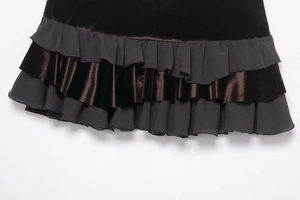 Detail view of the layered ruffles on a black velvet and brown satin mini skirt