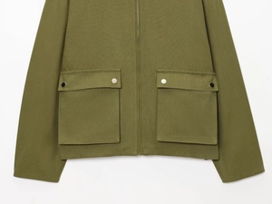 Close-up of olive green utility jacket showing durable twill fabric and flap pockets