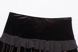 Detail of waist design showing velvet texture and matte ruffle trim on a short skirt