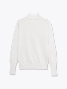 Detail of white turtleneck sweater showing ribbed cuffs and soft knit texture