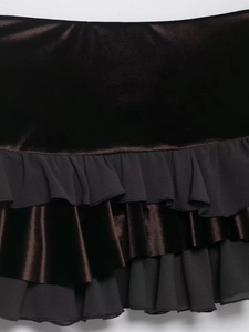 Close-up of tiered ruffle details on a black velvet and chiffon mini skirt