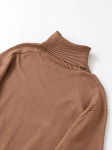 Close-up of brown turtleneck knit sweater showing ribbing details and fine stitching