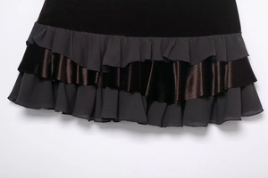 Detail view of tiered ruffles on a mini skirt with velvet and matte fabric textures