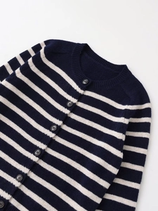Dettaglio ravvicinato del cardigan in maglia a righe blu navy con bottoni scuri