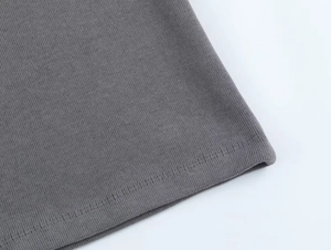 Close-up of dark grey ribbed knit fabric showing fine stitching and soft texture