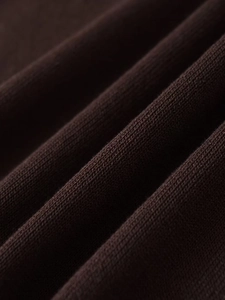 Macro shot of dark brown fine knit fabric showing soft texture and premium weave detail