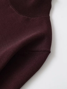 Detail of burgundy ribbed turtleneck and fine knit texture on long sleeve sweater