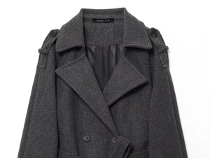 Detail of dark grey wool coat featuring a double-breasted closure and classic notched lapels