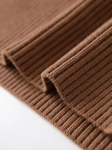 Detailed macro view of the brown ribbed knit texture on long sleeve sweater cuff