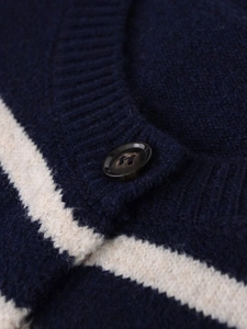 Dettaglio macro del cardigan a righe blu navy con colletto a coste e bottone rotondo