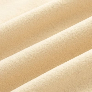 Macro detail of high-quality soft beige wool fabric texture with warm lighting