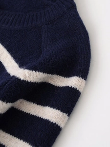 Dettaglio della morbida trama a maglia e del motivo a righe blu navy della giacca
