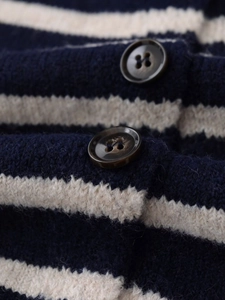 Vista macro del cardigan a maglia a righe blu e beige con bottoni in resina marrone