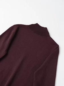 Detailed view of ribbed turtleneck and silver studs on wine red knit sweater