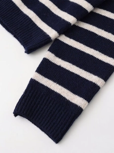 Dettaglio ravvicinato della manica del cardigan a righe blu e bianche con polsini a coste