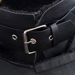 Détail de la veste en cuir noir avec boucle métallique et doublure en polaire chaude