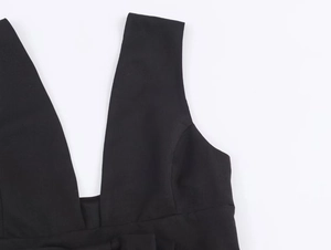Détail d'une robe noire élégante avec décolleté en V profond et texture du tissu
