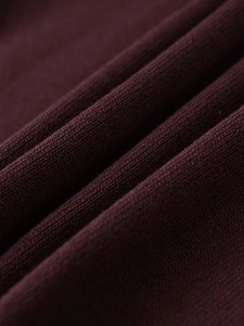 Macro close-up of dark burgundy fine knit fabric texture and soft woven fibers