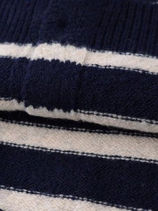 Dettaglio ravvicinato del tessuto in maglia a righe blu navy e crema con trama morbida
