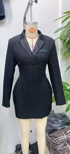 Detail of waist pleats and cinched tailoring on this black long-sleeved blazer dress