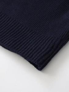 Detailed close-up of dark blue ribbed knit fabric on a stylish short cardigan