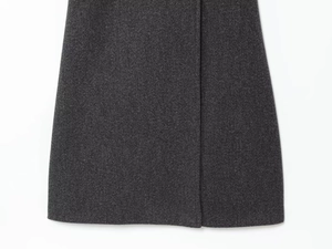 Detail of dark grey wool blend fabric texture and stitching on a long overcoat hem