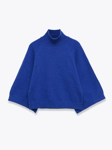 Detail of royal blue turtleneck knit sweater with raglan sleeves and ribbed cuffs