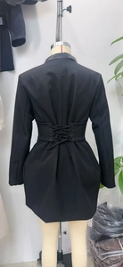 Detail of the back lace-up design on this black long-sleeve blazer dress with metal rings