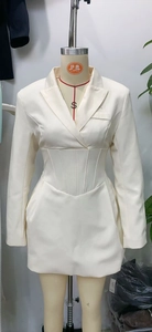 Detail of white blazer dress showing V-neck design and structured cinched waistline