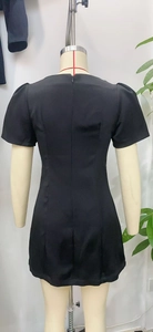 Détails d'une robe noire à manches courtes avec taille ajustée et fermeture éclair au dos