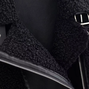 Gros plan sur la matière effet mouton noir et les détails en cuir mat du blouson biker