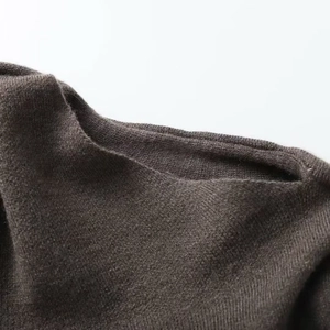 Détail du tricot anthracite foncé montrant des coutures denses et une texture douce