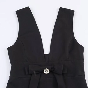 Robe courte noire sans manches avec col en V, nœud élégant et détail de bijou en cristal