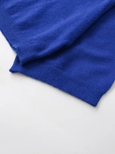 Detailed view of the ribbed cuff and soft knit texture of the blue pullover sweater