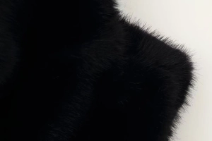 Close-up of high-quality black faux fur texture showing soft plush fibers and rich detail