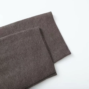 Vue détaillée de la texture du tissu tricoté gris foncé sur le manteau court chic