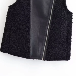 Détail du gilet noir en polaire et cuir PU avec une fermeture éclair en métal argenté