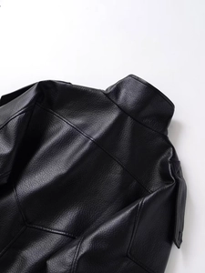 Close-up of black leather jacket with lychee grain texture and stand collar detail