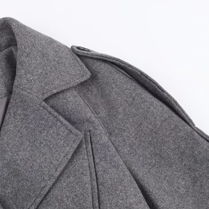 Détail d'un manteau en laine gris foncé avec revers, épaulettes et coutures soignées