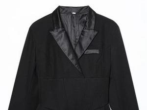 Detail of elegant black suit dress featuring satin lapel and slim fit cinched waistline