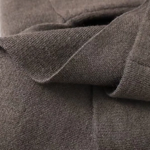 Gros plan sur la texture du tricot marron doux et le motif de tissage du manteau court