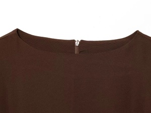 Détail de l'encolure d'une robe en tricot marron foncé avec fermeture éclair en métal argenté