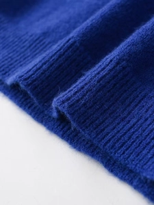 Macro view of blue knit sweater fabric showing fine ribbing details and soft texture