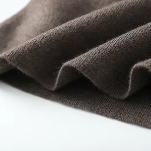Gros plan sur un tricot marron foncé avec des coutures fines et une texture très douce
