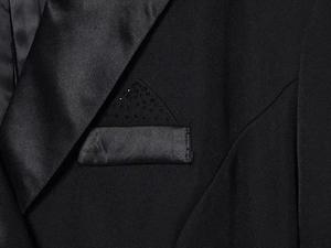 Detailed close-up of a black blazer dress featuring a satin lapel and beaded pocket square